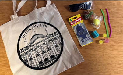 a number of random objects on a table, bag, air freshener