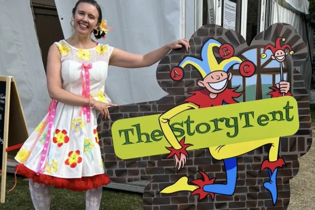 Sarah Sparkles holds a sign saying The Story Tent