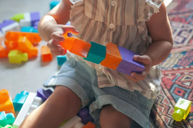 Image of a toddler playing with toy bricks