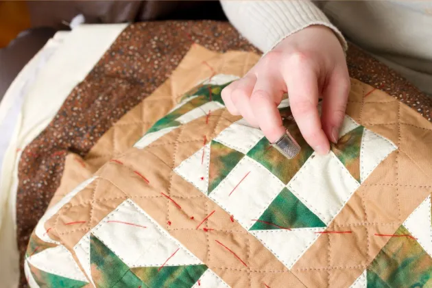 Image of quilt being made by quilters showing their hands