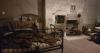 a tenement replica with a bed, a chair and a fireplace