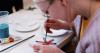 woman paints handmade christmas decoration