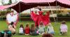 two dancers in colourful dresses spin in front of children