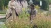 Three figures dressed in historic clothing in a park 