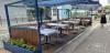 tables with table cloths, chairs, umbrellas and ash trays on the street outside Bang Restaurant