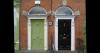 Front face of two buildings with a green and black door