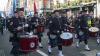 Pipe band marching down the street with cheering crowds