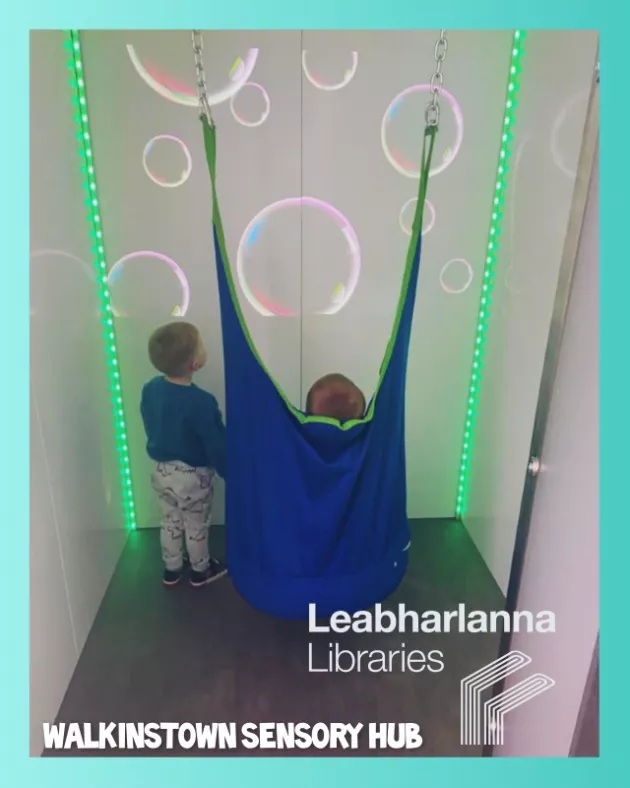 Two young children watching bubbles in the sensory cubbie at Walkinstown Library