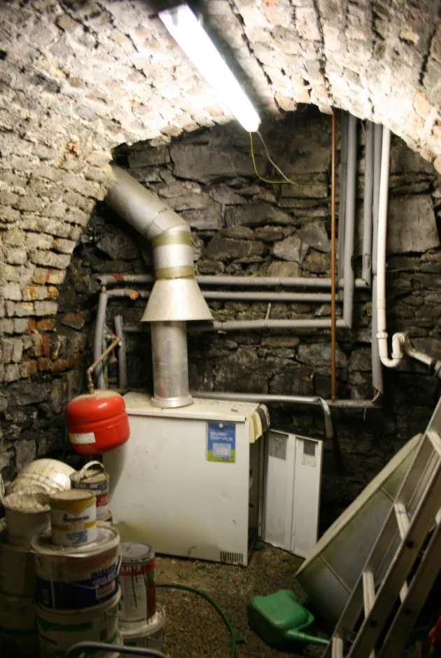 60kw gas boiler is located externally in a cellar area; note exposed primary pipework is poorly lagged