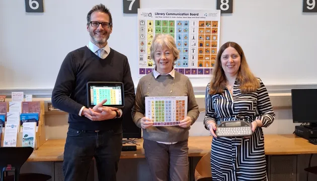 Three people posing with AAC devices