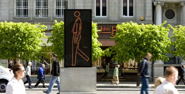 Street sign, with people walking past