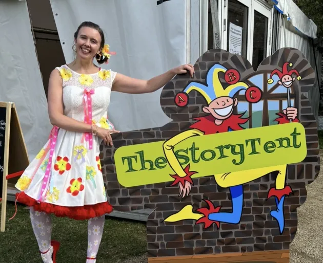 Sarah Sparkles holds a sign saying The Story Tent