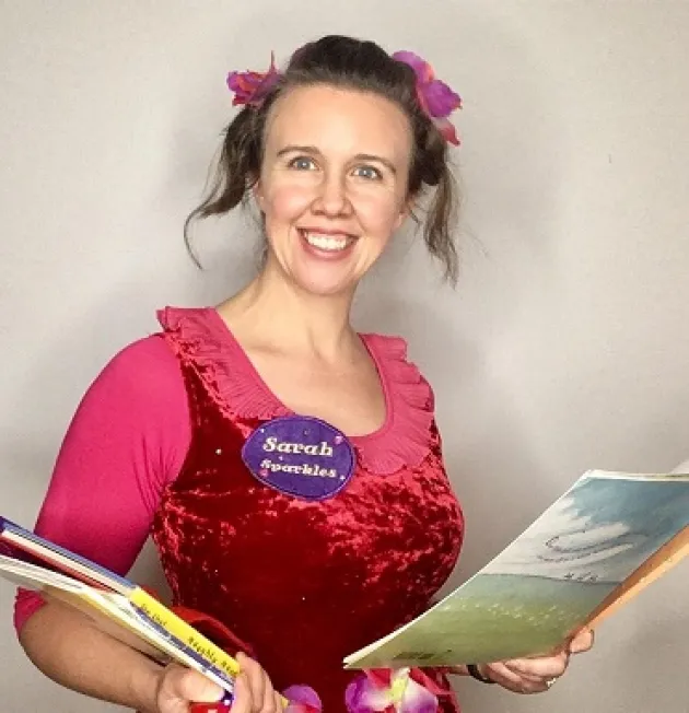 Sarah Sparkles holding books and smiling at the camera