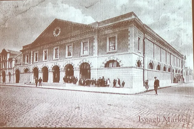 Historic photograph of the Iveagh Markets building shortly after completion, showing the exterior façades and people gathered along the street.