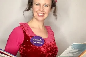 Sarah Sparkles holding books and smiling at the camera