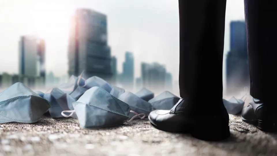 A guys standing with covid masks on the ground